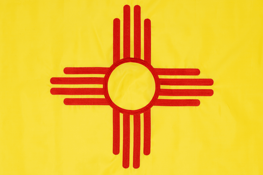New Mexico state flag close-up with red Zia symbol on yellow field