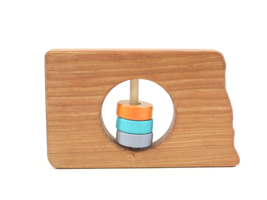 North Dakota state-shaped cherry wood baby rattle with colored center disks
