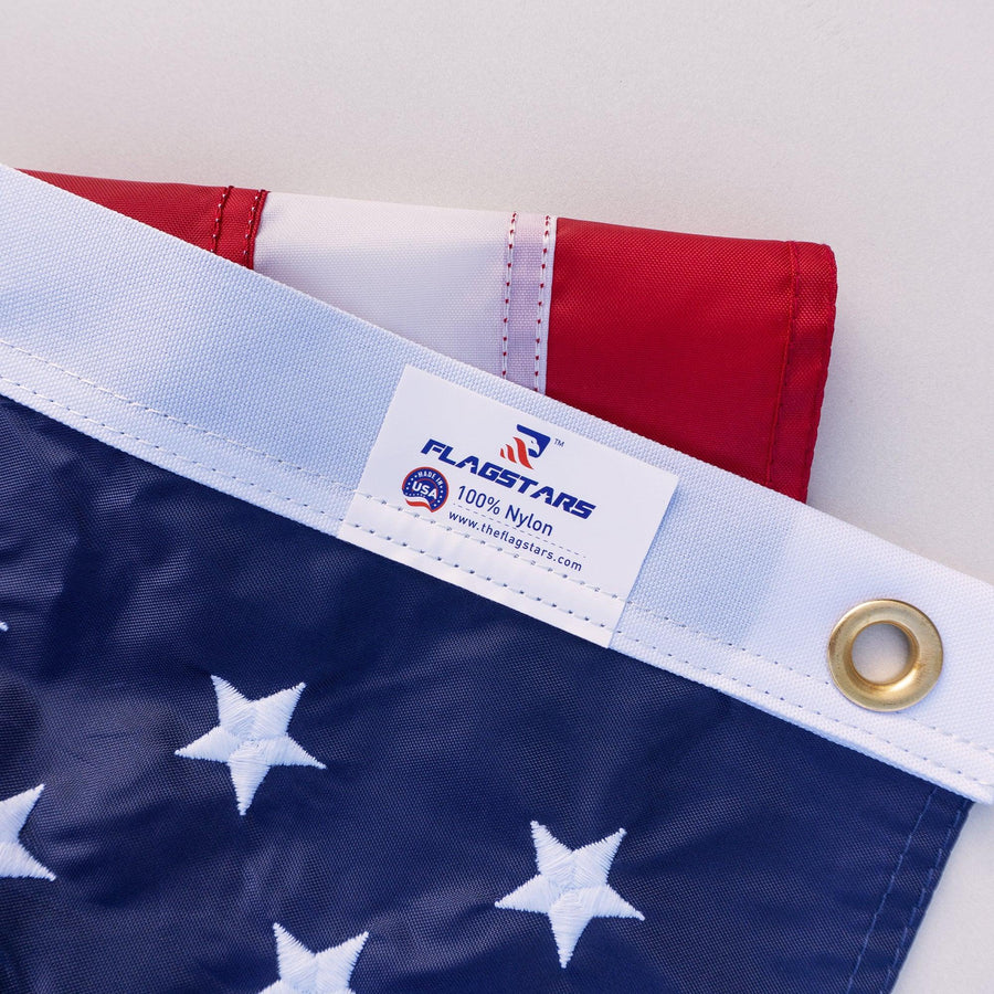 Close-up of nylon American flag embroidered stars, reinforced header and brass grommet