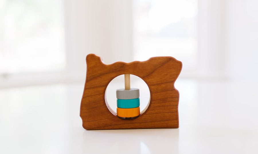 Oregon state-shaped cherry wood baby rattle with colored center disks