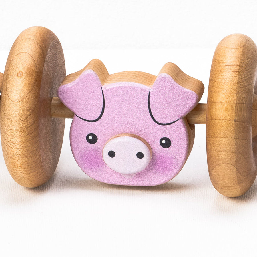 Pig-face detail on a wooden rolling animal toy