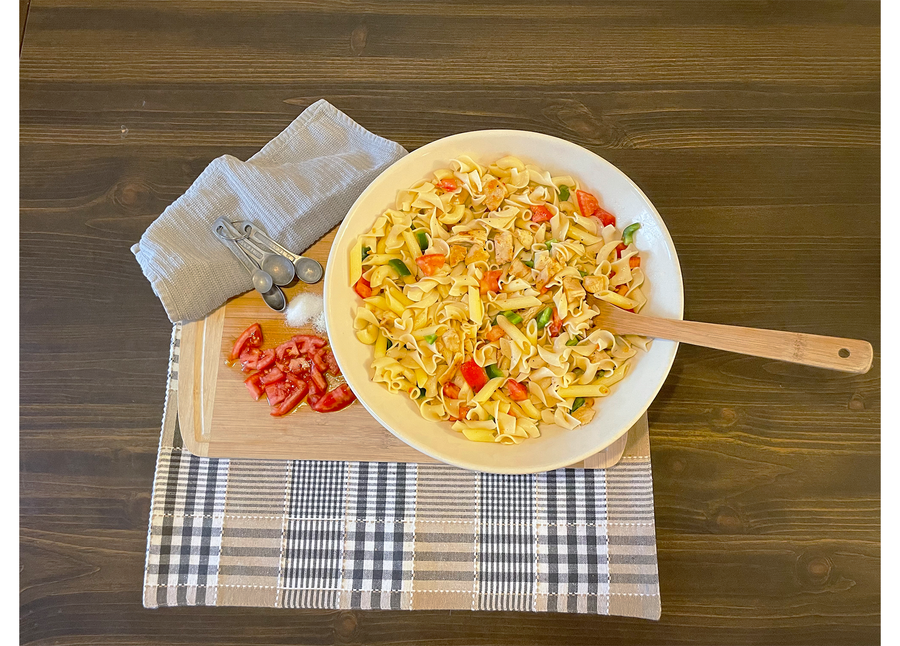 Overhead view of pasta served in a blue-striped stoneware bowl