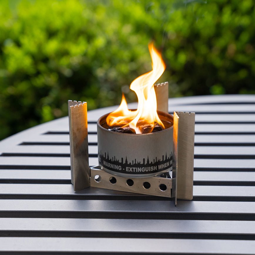 Camp stove and burning bonfire in an outdoor table setting