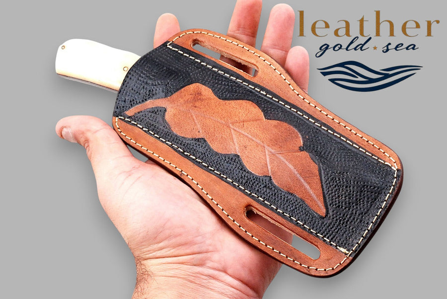 Hand holding horse-motif leather sheath with demonstration knife