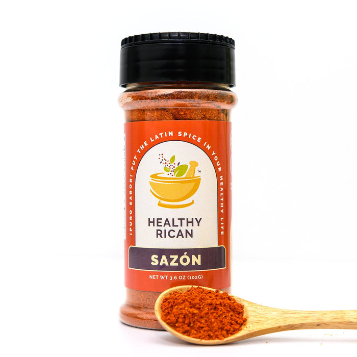 Sazón seasoning jar beside a wooden spoon of orange-red spice blend