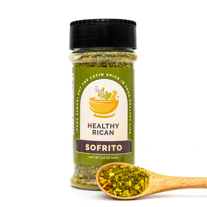 Sofrito seasoning jar beside a wooden spoon of dried vegetables and herbs