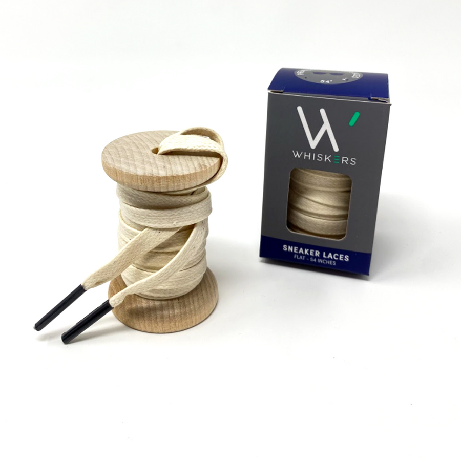 Cream glazed cotton shoelaces on a wooden spool beside the retail box