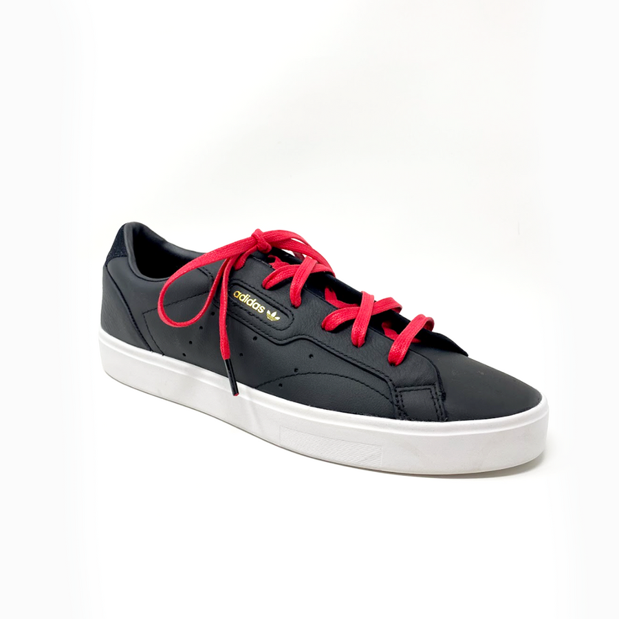 Red glazed cotton shoelaces laced into a dark gray sneaker