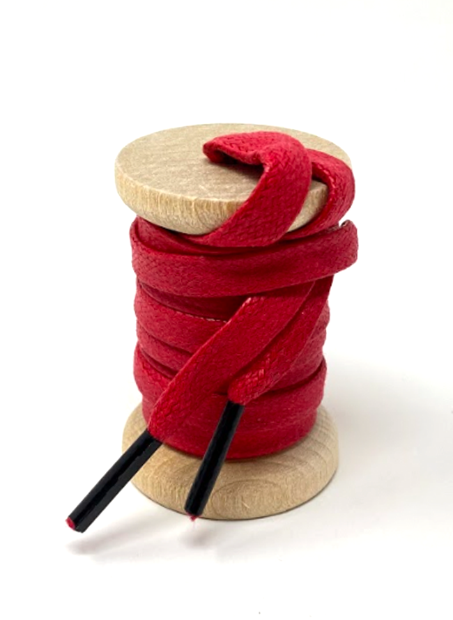 Red glazed cotton shoelaces on a wooden spool