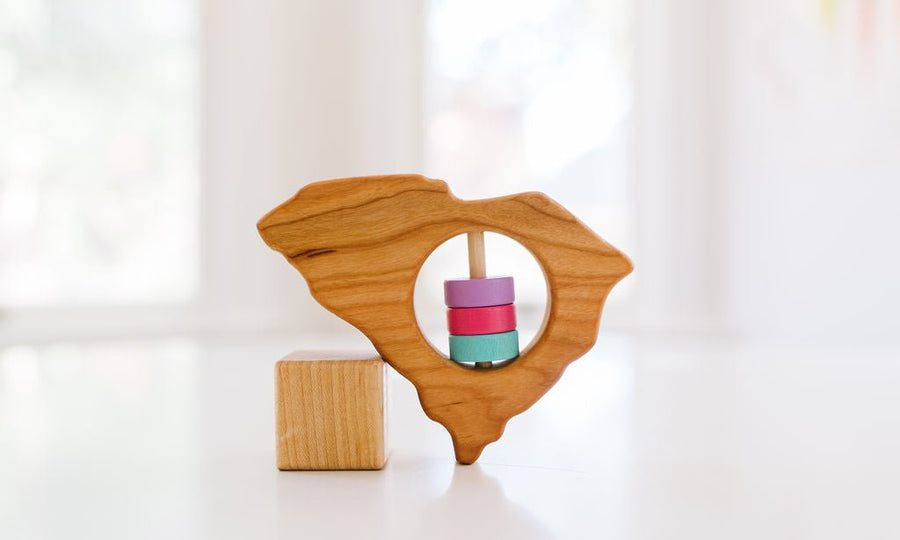 South Carolina state-shaped cherry wood baby rattle with colored center disks