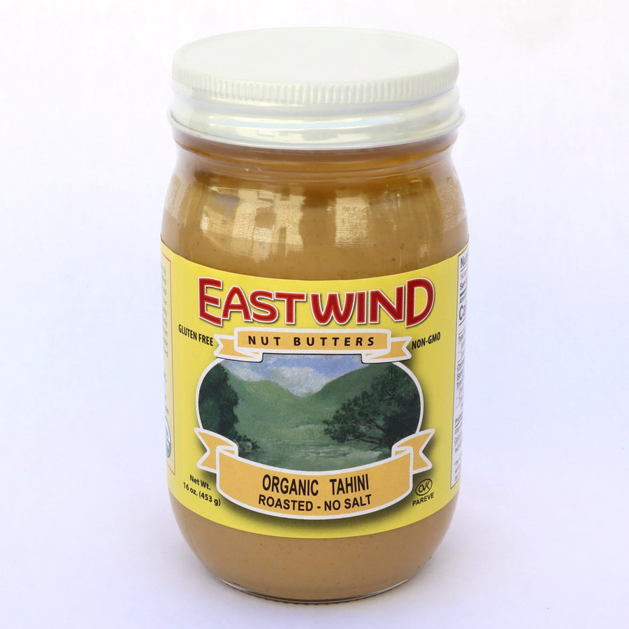 16 oz glass jar of East Wind organic roasted tahini on a white background