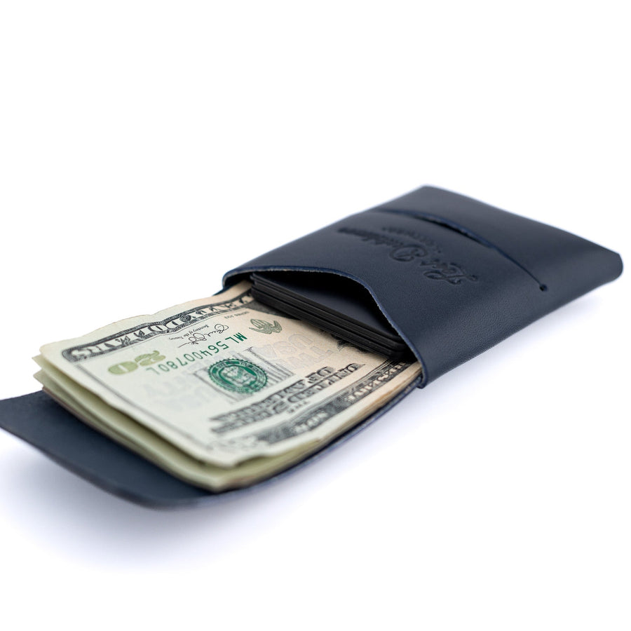 Navy Franklin leather wallet, angled view with cash in the wrap