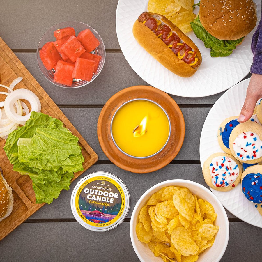 Citronella candle photographed from above with cookout food