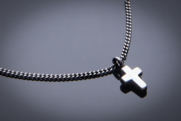 Mini Cross of Comfort charm on a dark chain