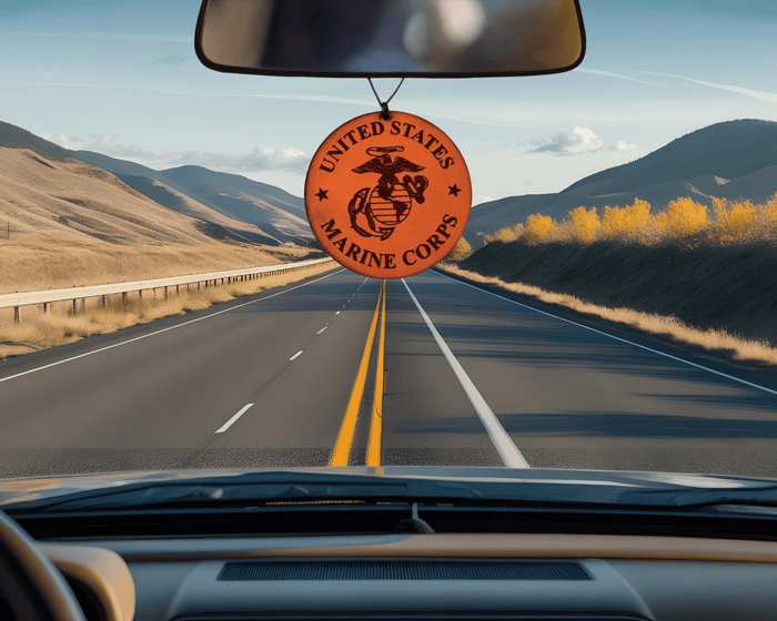 Round Marine Corps emblem leather car air freshener pictured below a rearview mirror