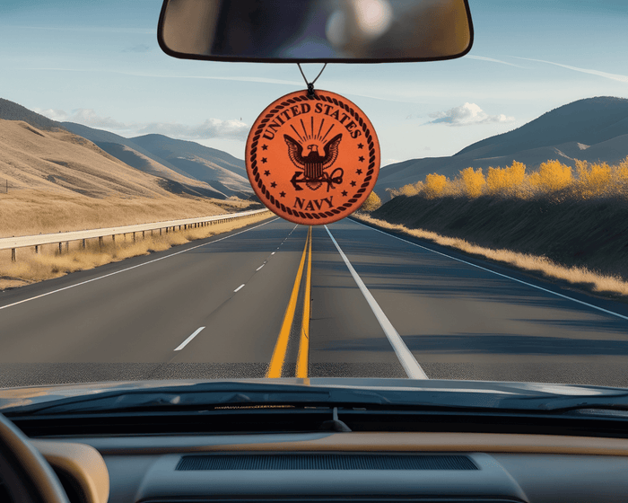 Round Navy emblem leather car air freshener pictured below a vehicle rearview mirror