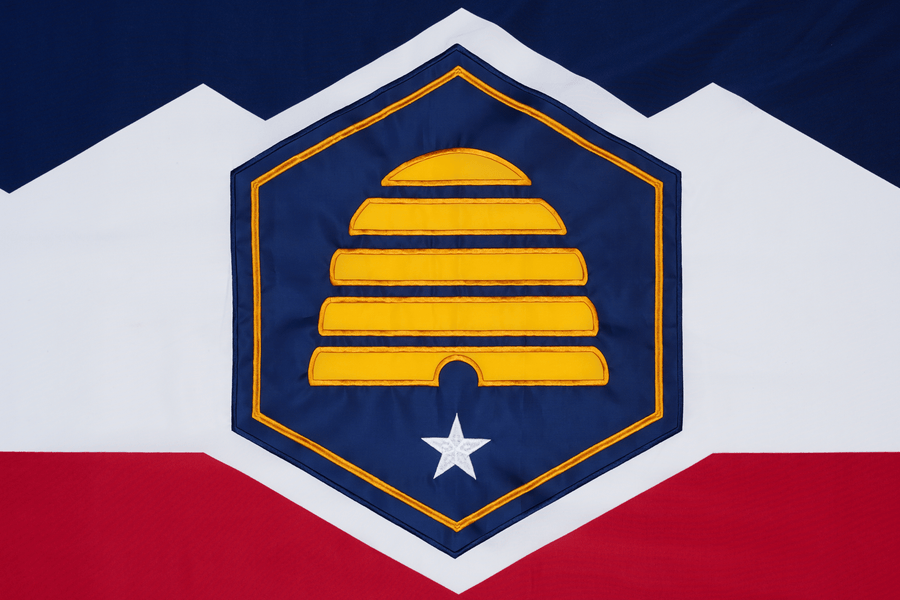 Utah state flag close-up with beehive white star mountains and red field