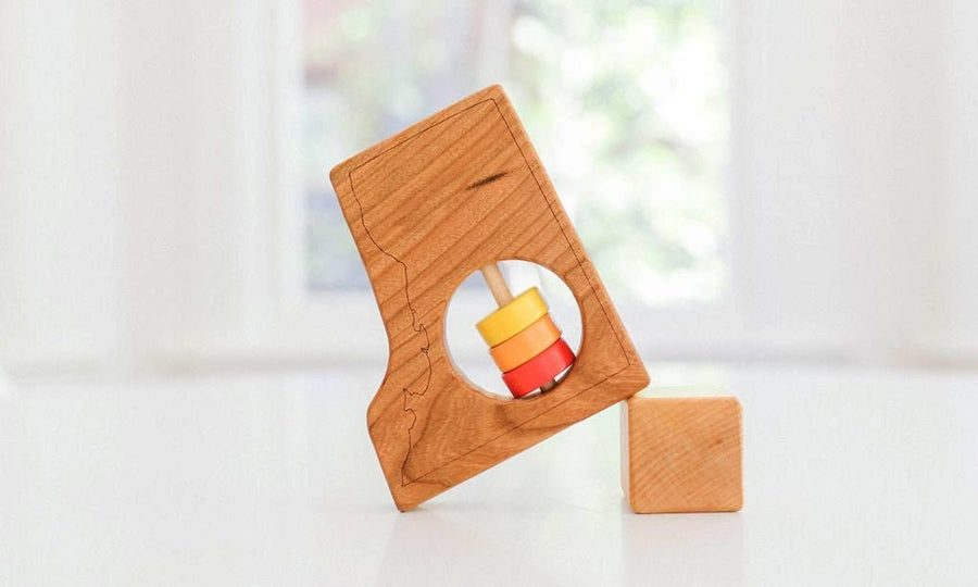 Washington DC state-shaped cherry wood baby rattle with colored center disks