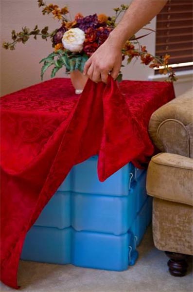 WaterBrick containers beneath a table being covered with a cloth