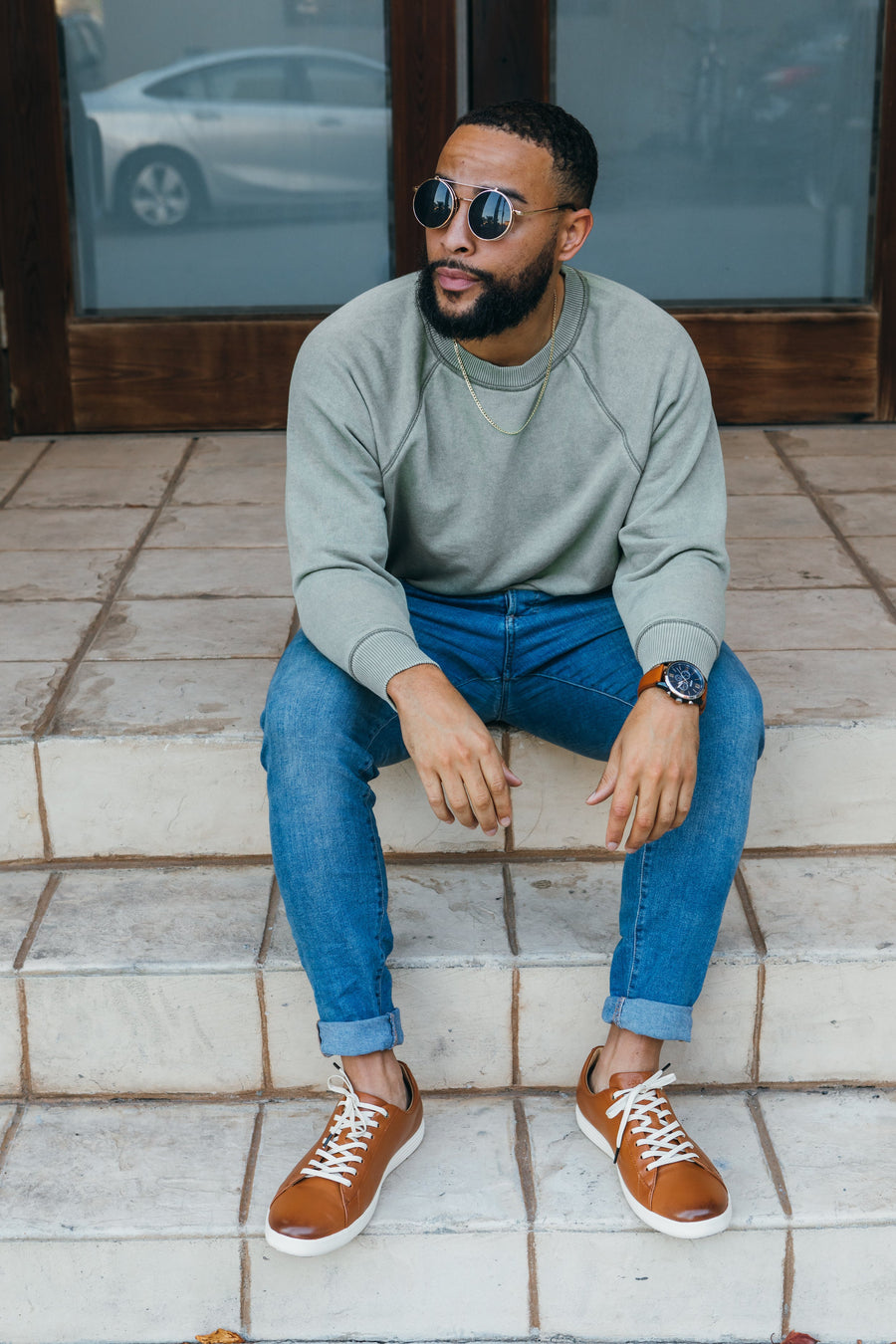 Cream glazed cotton shoelaces worn with brown sneakers while seated outdoors