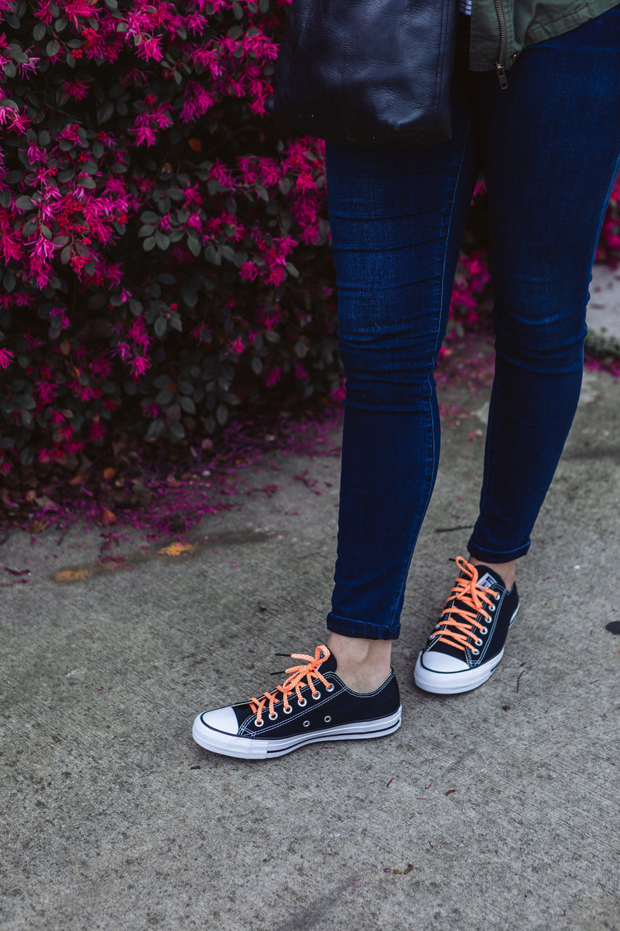 Neon Orange & Navy ticked flat shoelaces worn with black high-top sneakers outdoors
