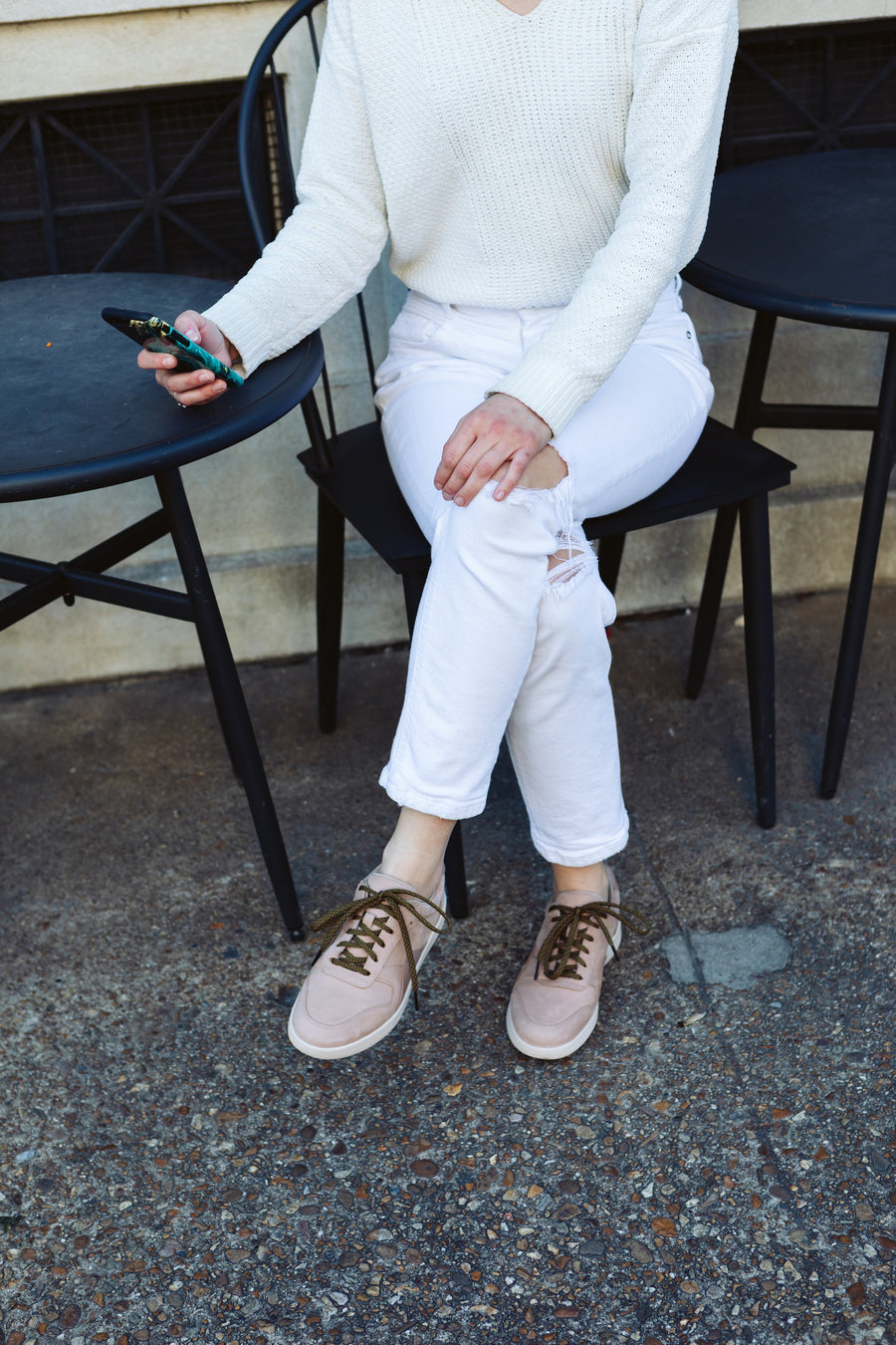 Olive Green & Guava ticked flat shoelaces worn with low-top sneakers while seated outdoors