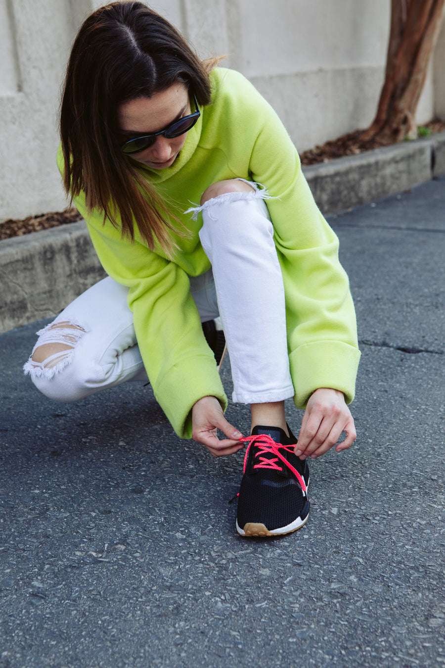 Neon Pink & Red ticked flat shoelaces being tied on dark sneakers outdoors