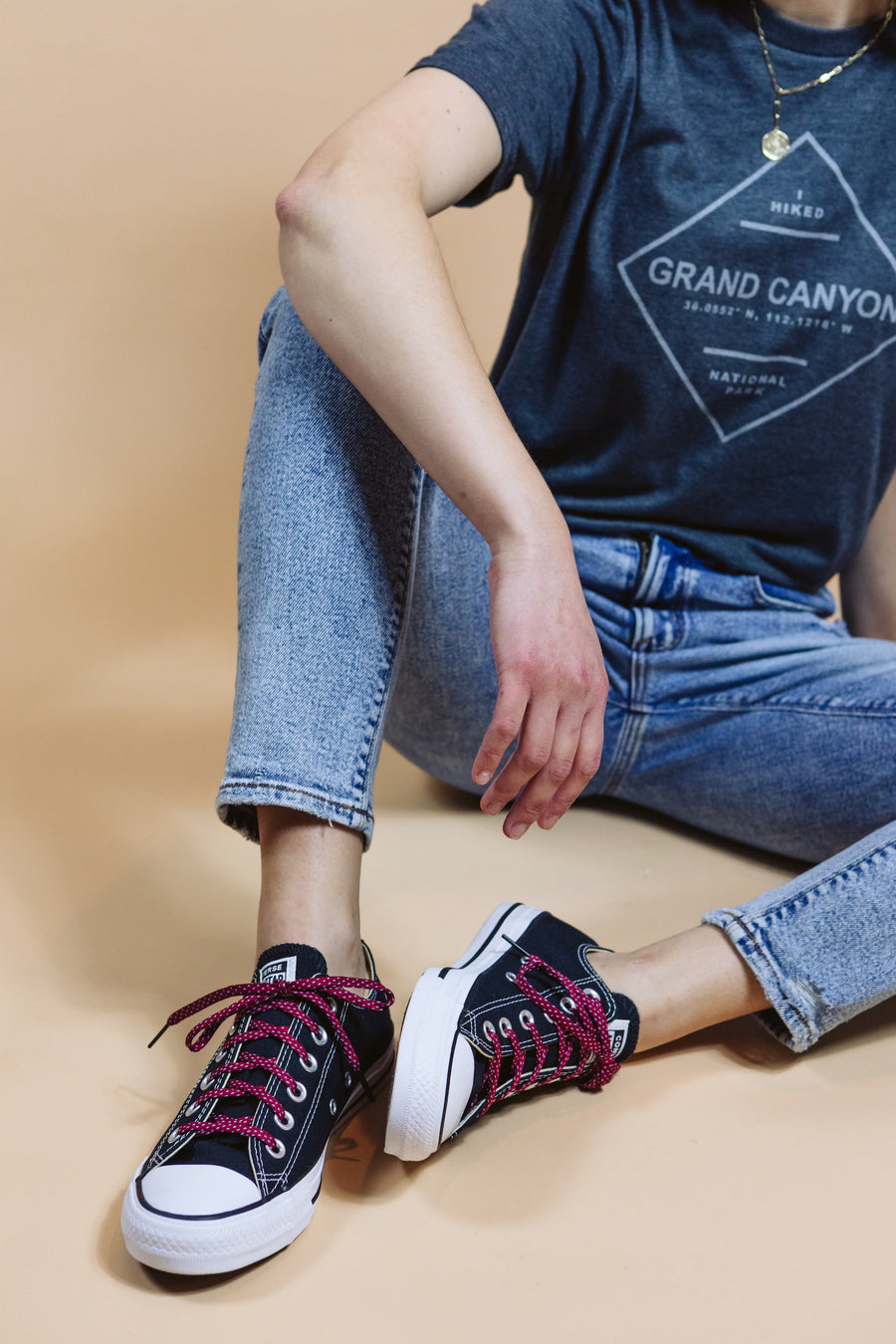 Garnet & Light Blue ticked flat shoelaces worn with high-top sneakers while seated outdoors